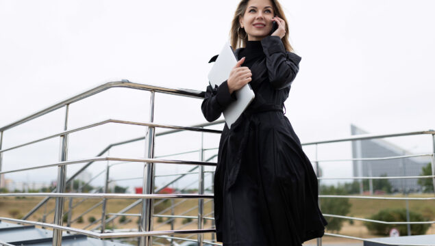 confident business woman talking on the phone using internet connection on steps of campus building