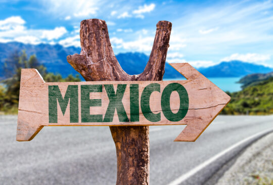 Mexico wooden sign with road background